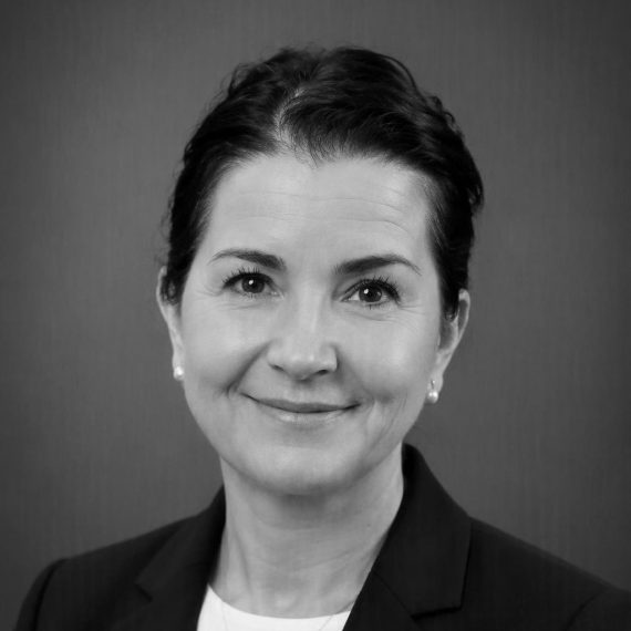 Black and white headshot of Abby Sears, smiling while looking at the camera.