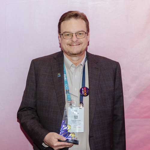 AdaptIntegrated-Impact-square 2025 Learning Forum Impact Award Winner holding award