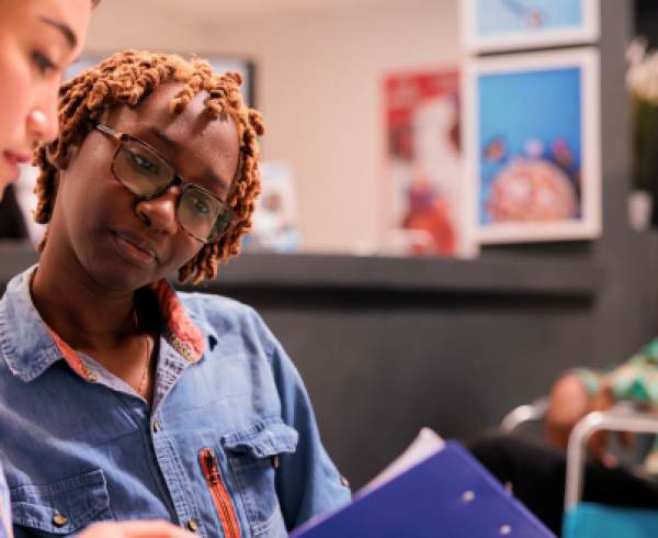 Healthcare professionals reviewing patient care information in a community health clinic, demonstrating care coordination, healthcare services, and patient-centered support.