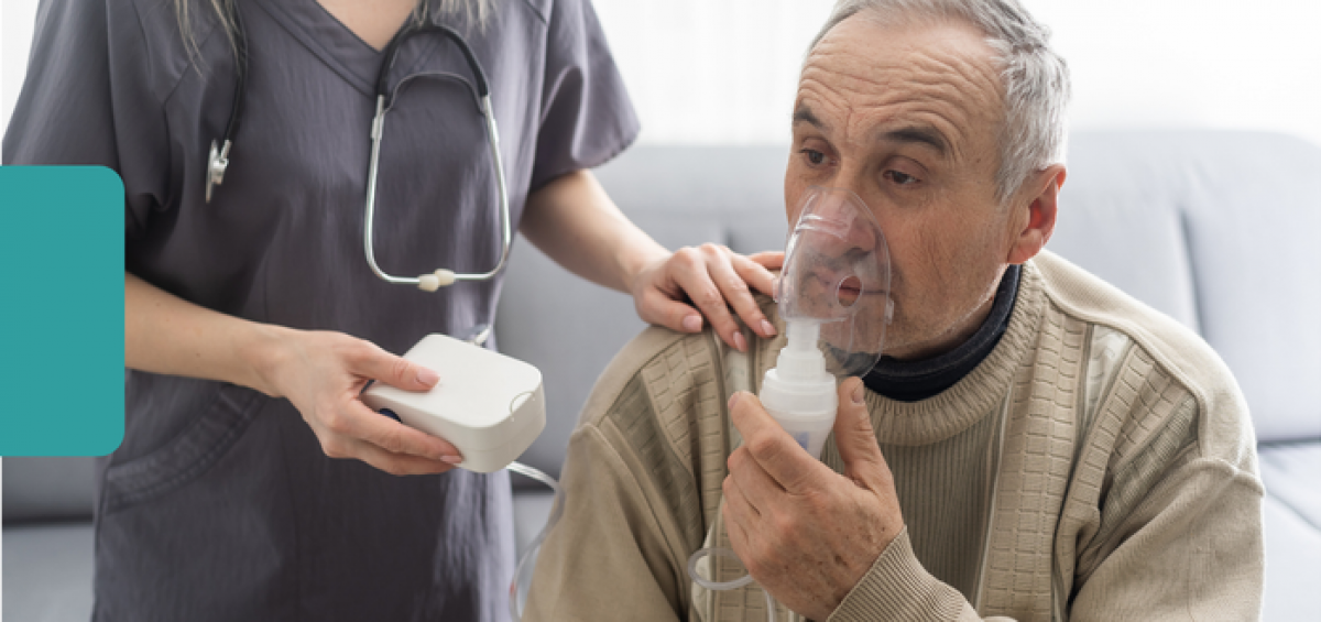 A patient uses a nebulizer mask while receiving support from a health care team member during a clinic visit.